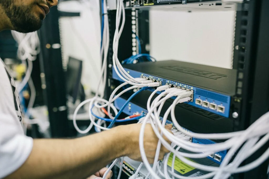 Man working on a switch in a business server room during IT project services.